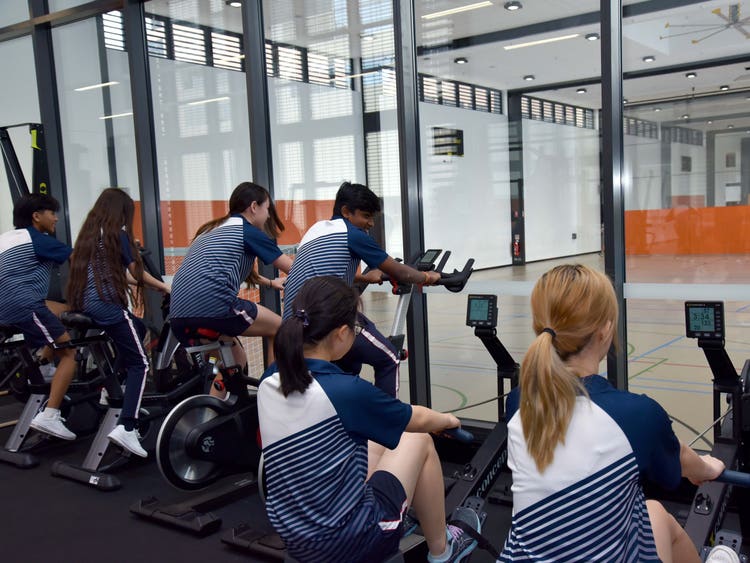 Students using the fitness lab overlooking the gym courts