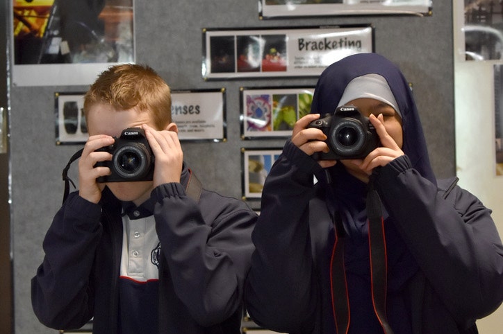 Two students using DSLR cameras